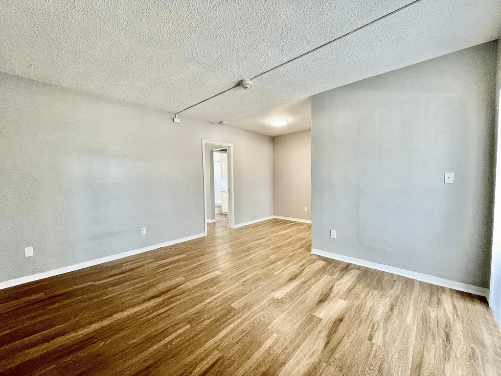 an empty living room with a hardwood floor at Lakeside @ Biscayne Gardens,North Miami
