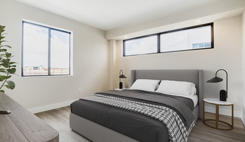 a bedroom with a bed and three windows