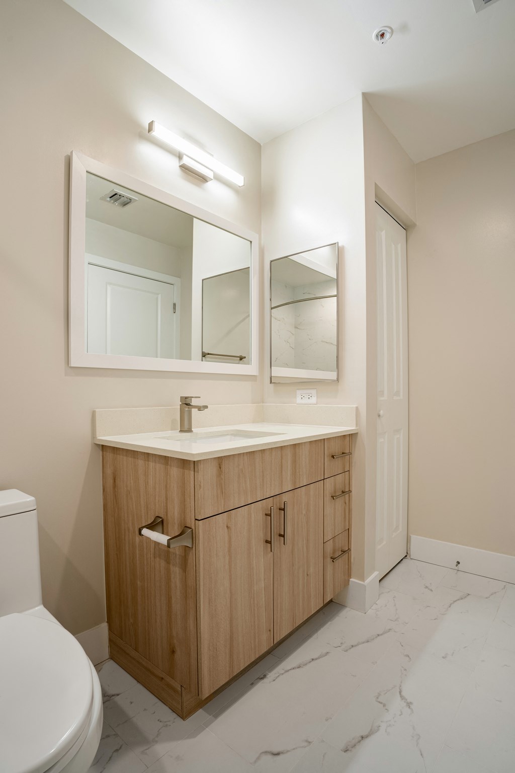 a bathroom with a sink and mirror and a toilet