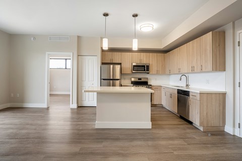 an empty kitchen with wooden cabinets and a white counter top