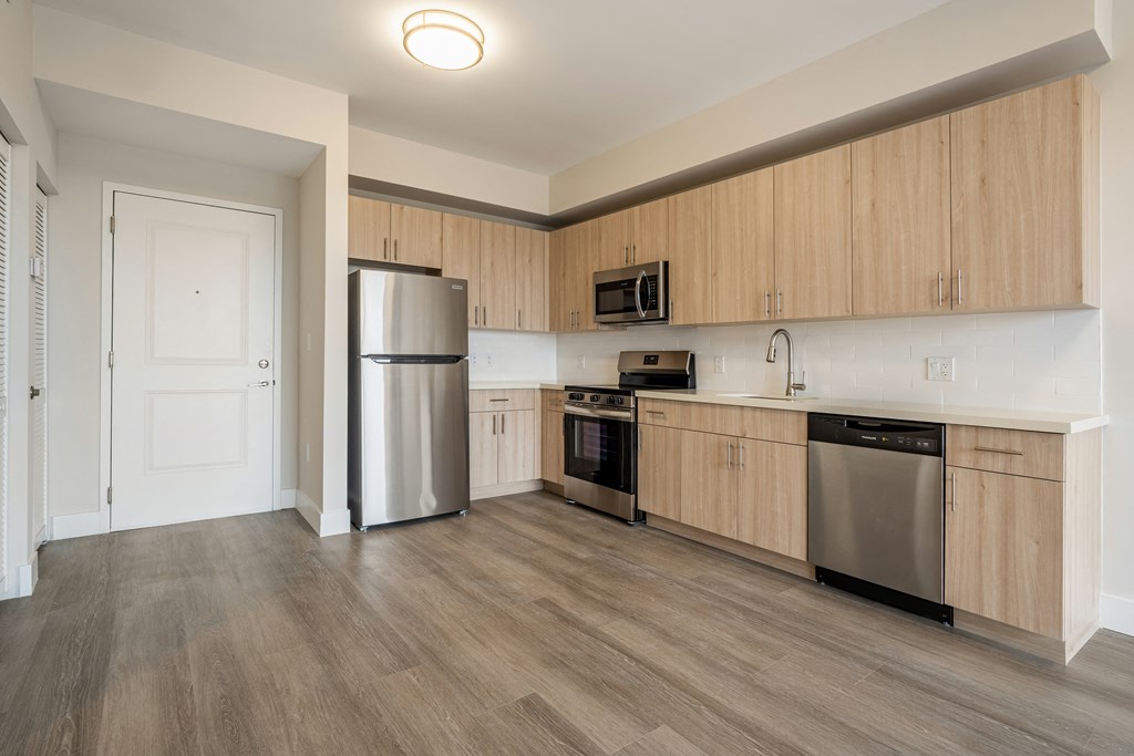 a kitchen with wooden cabinets and stainless steel appliances