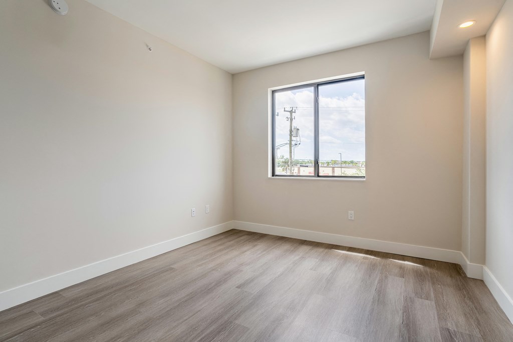 an empty room with wood floors and a window