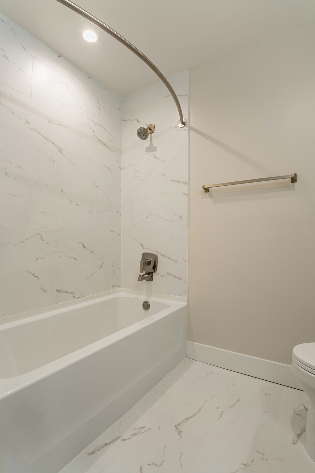 a white bathroom with a tub and a toilet