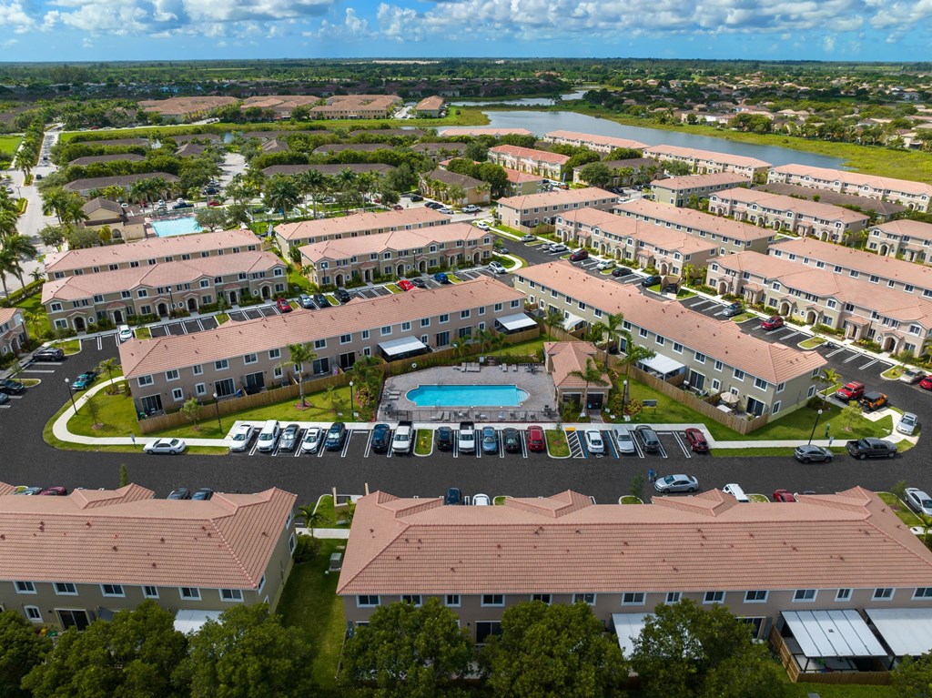 an aerial view of a parking lot with buildings and a pool