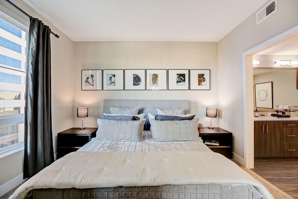 a bedroom with a bed and framed pictures on the wall