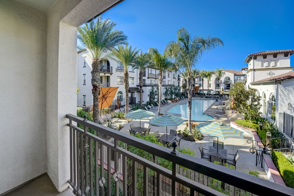 a balcony with a view of a swimming pool and resort buildings