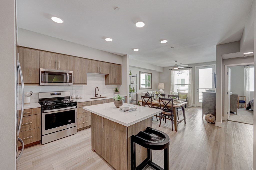 Open kitchen and dining room with wooden cabinets and white countertop