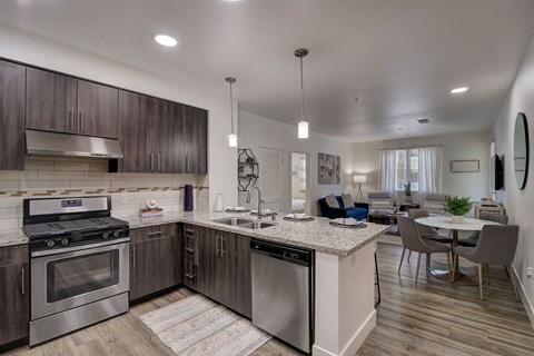 an open kitchen with stainless steel appliances and a marble counter top