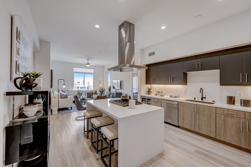 Open kitchen and living room with large white island and stools