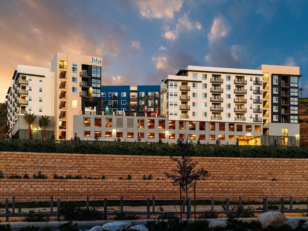 a rendering of a building with a brick wall in front of it