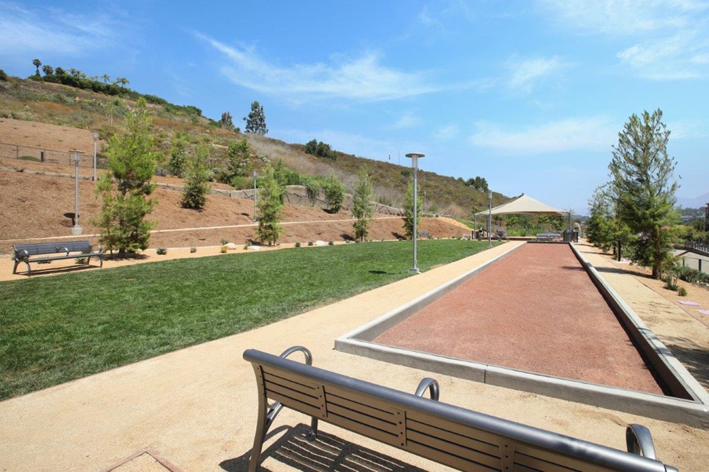 a park bench in front of a dirt field