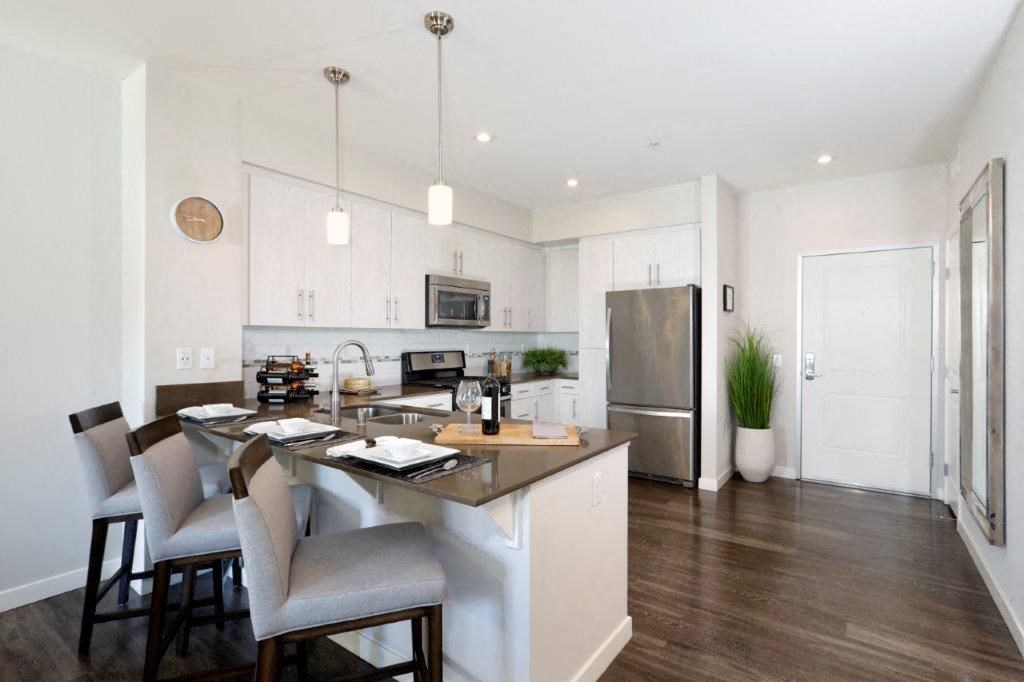 a kitchen with a large island and a stainless steel refrigerator