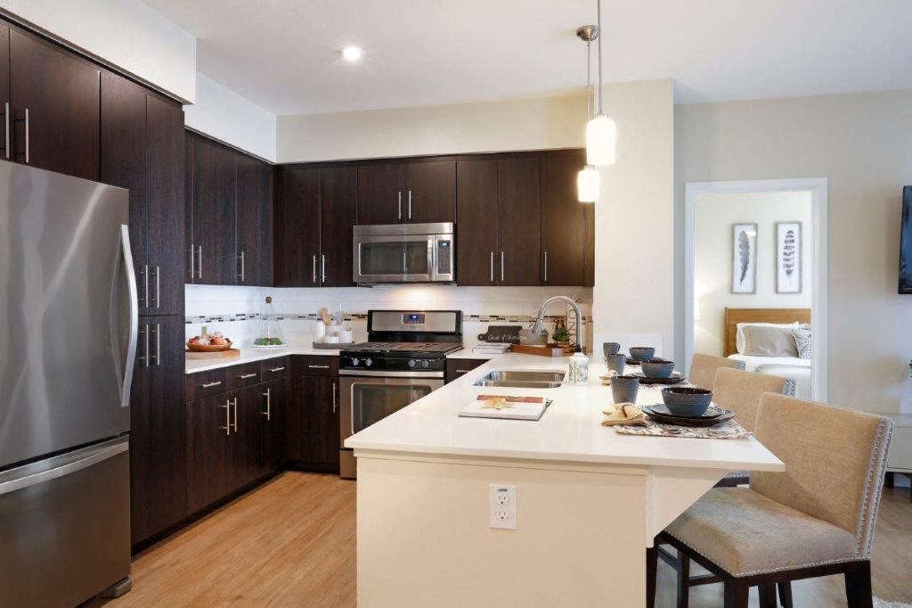 a kitchen with a large island and a stainless steel refrigerator