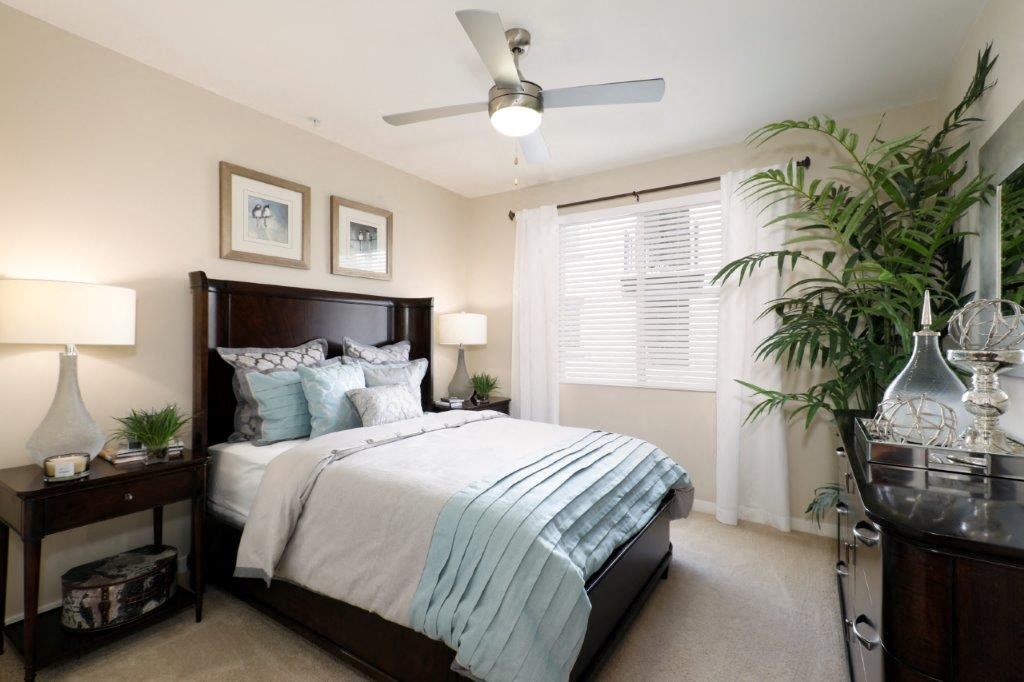 a bedroom with a large bed and a ceiling fan