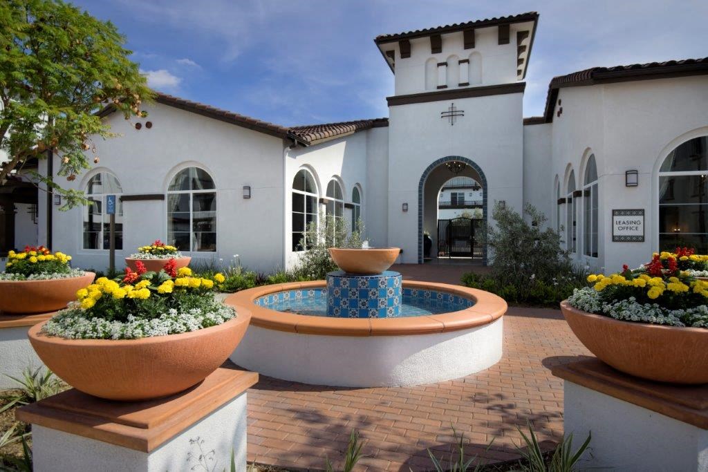 a courtyard with a fountain in front of a building