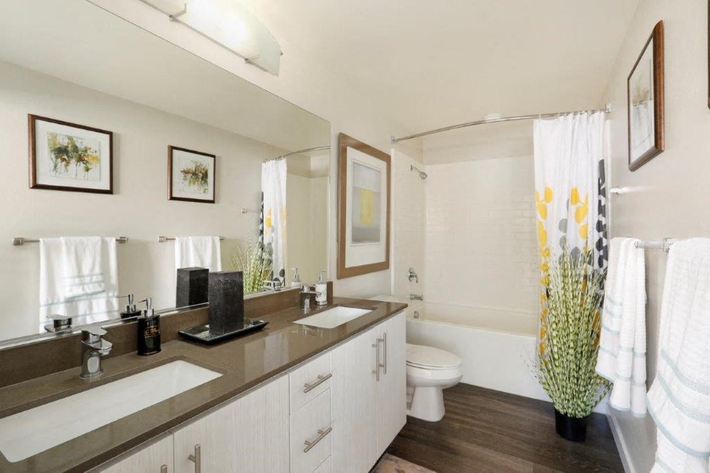 a bathroom with two sinks and a toilet and a mirror