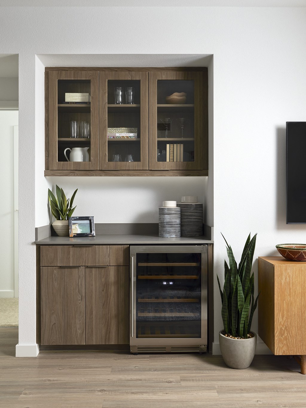 a kitchen with wooden cabinets and a plant next to a tv