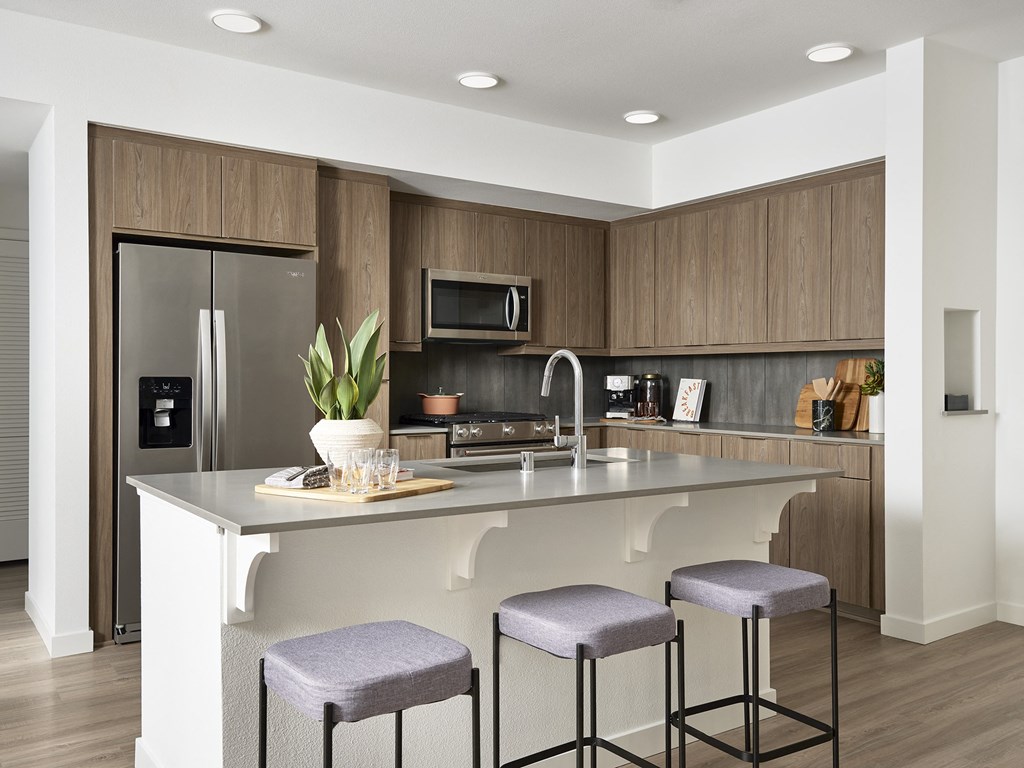 a kitchen with a large island with three stools