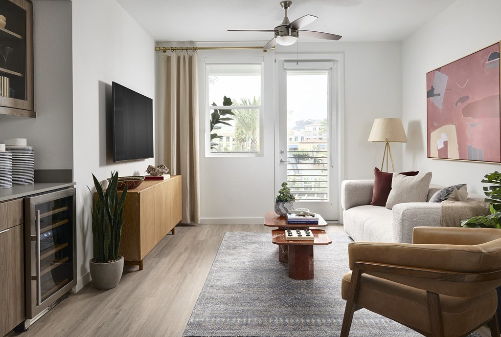 a living room with a large window and a ceiling fan