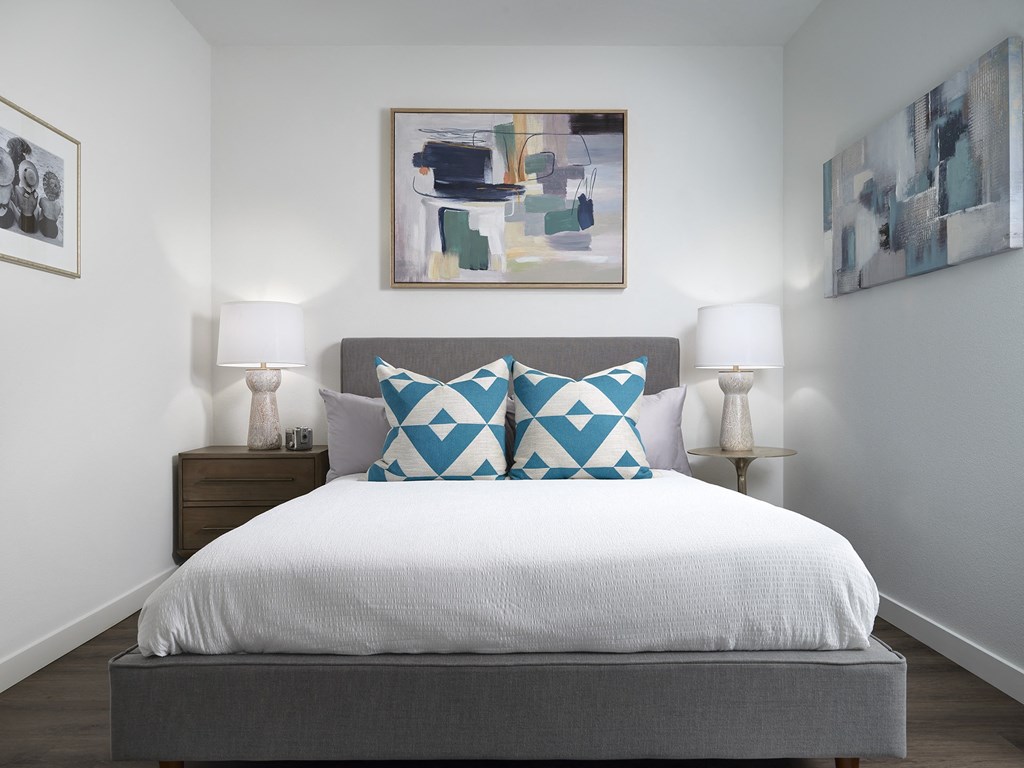 a bedroom with a bed and paintings on the wall