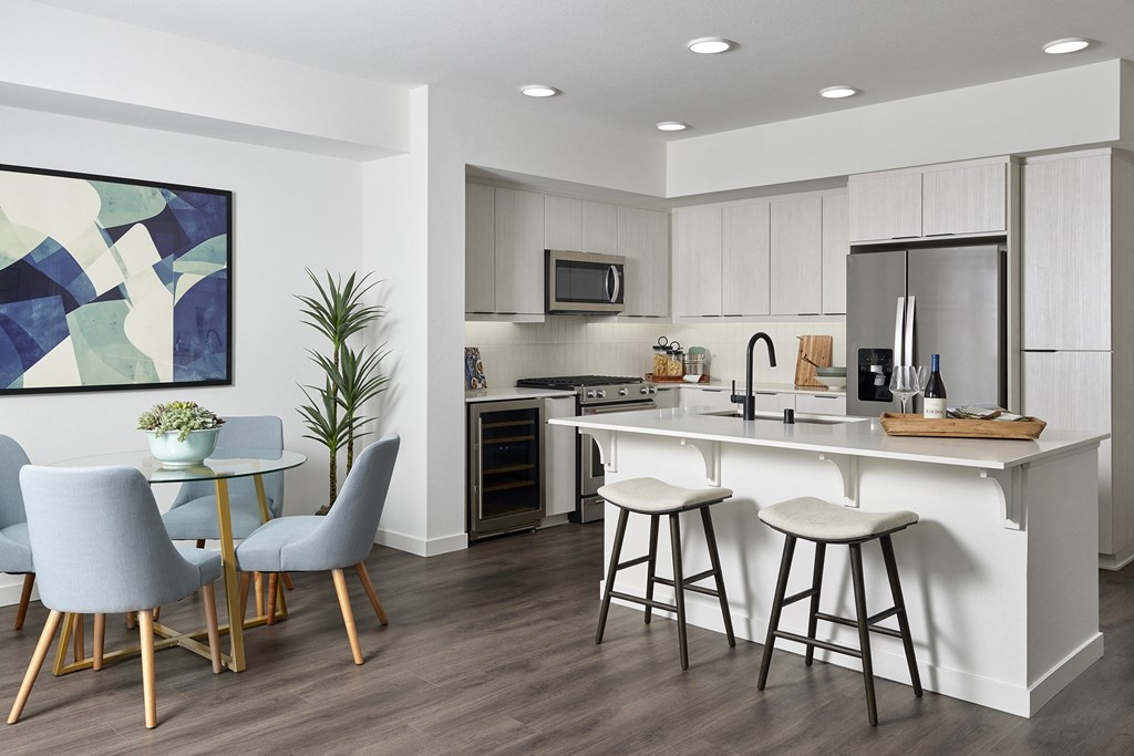 an open kitchen and dining area with a bar and stools