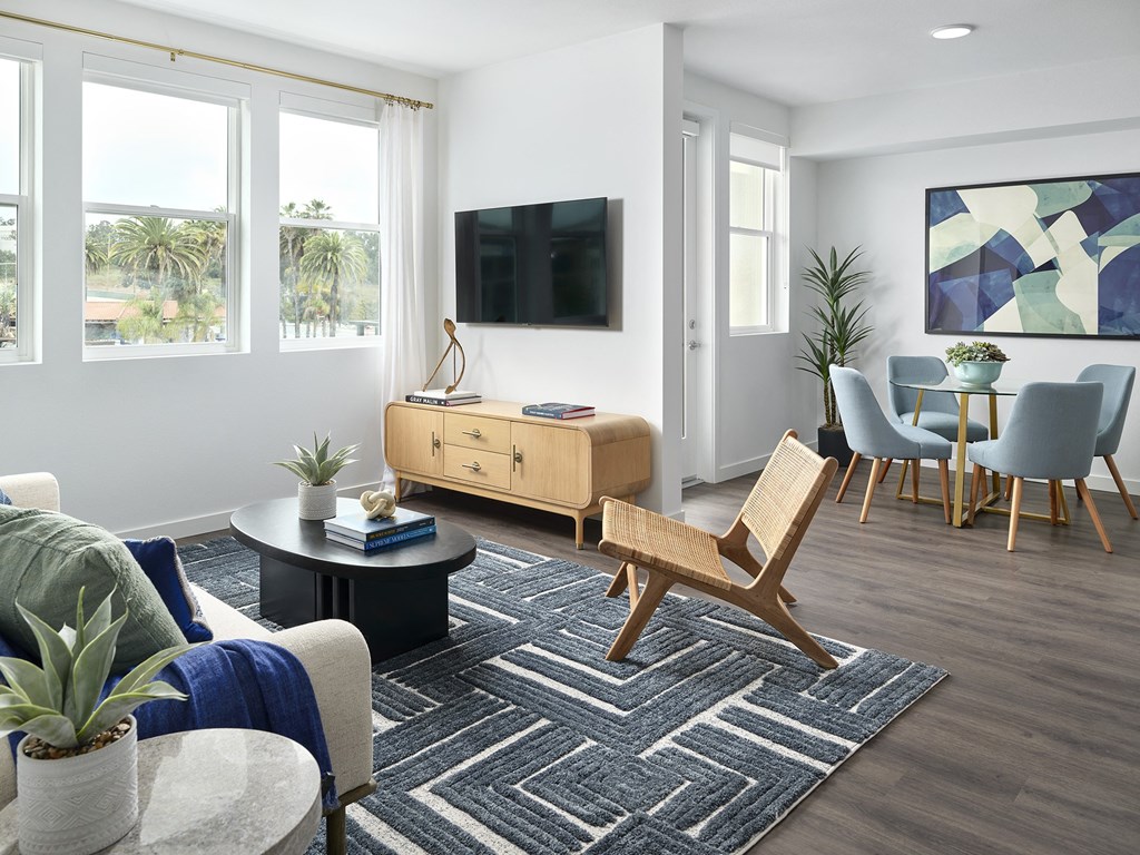 a living room with a couch and a table with chairs and a television