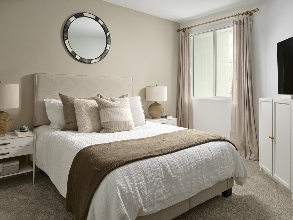 a bedroom with a bed and a mirror above it