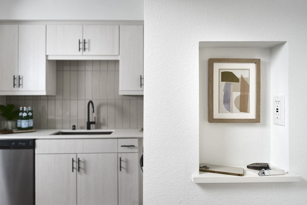 a kitchen with white cabinets and a picture on the wall
