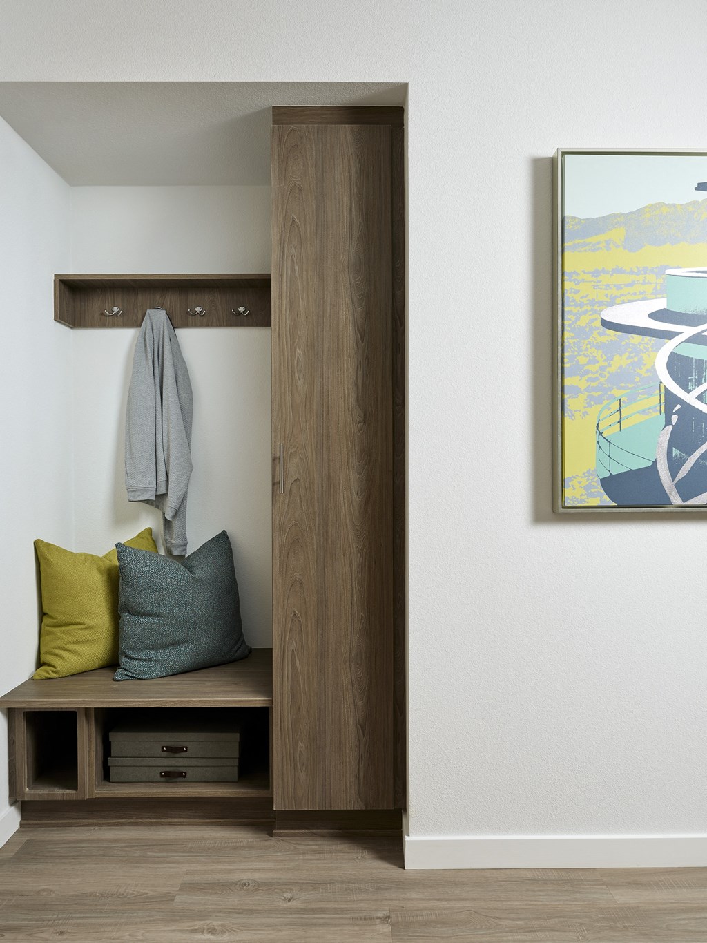 a hallway with a bench with pillows and a door to a closet