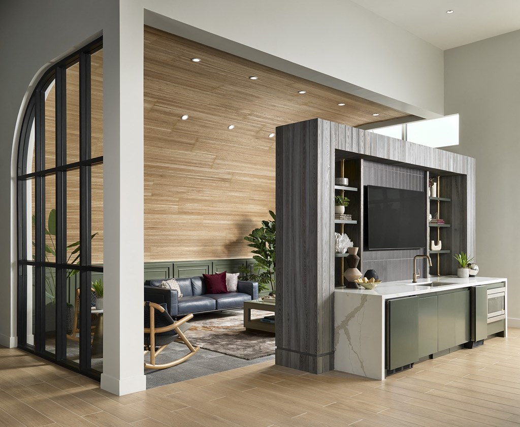 a living room with a kitchen and a large glass door