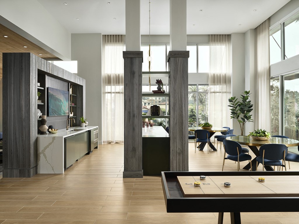 the living room and dining area of a modern house with large windows