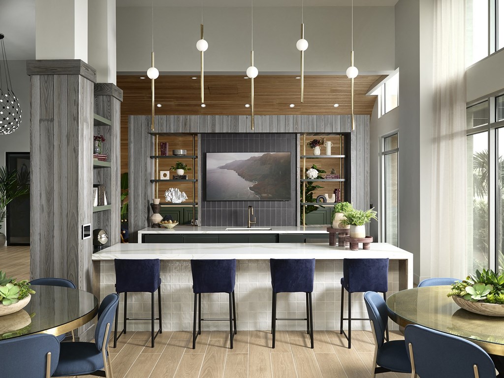 a kitchen with a marble counter top and blue chairs