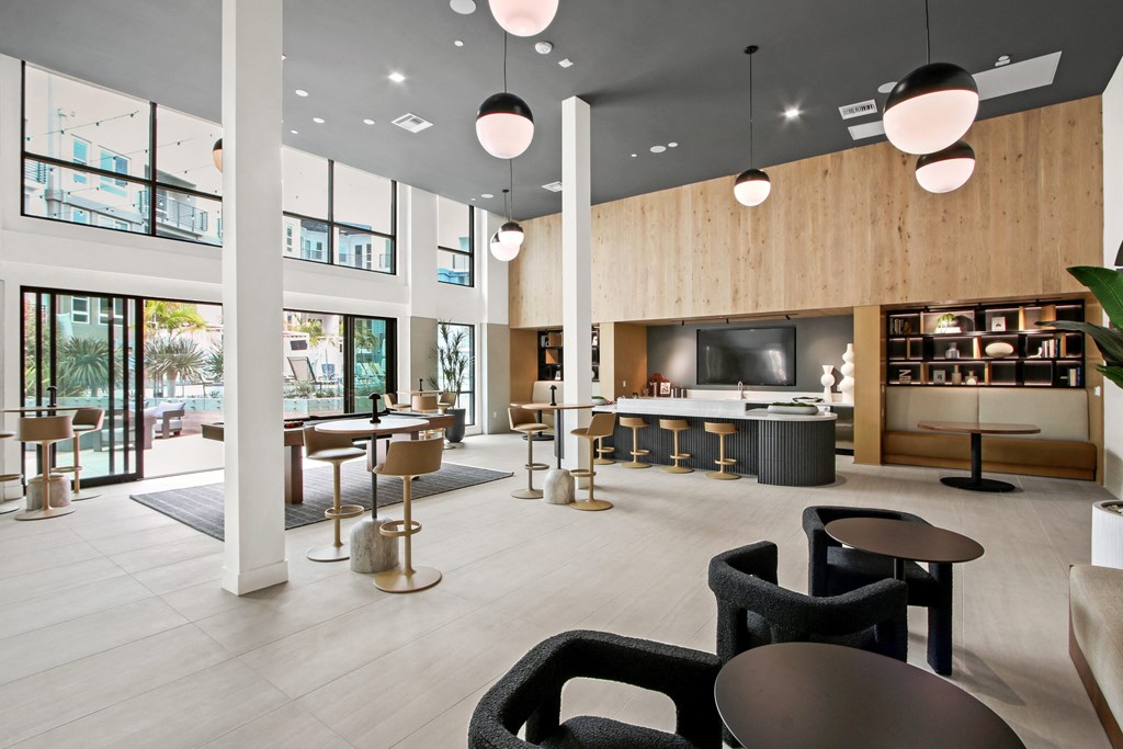 a large lobby with tables and chairs and a tv