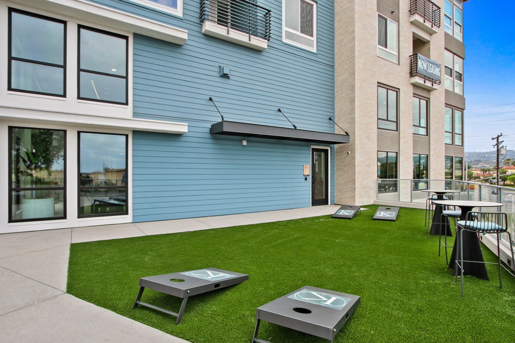 a patio with tables and chairs in front of a building