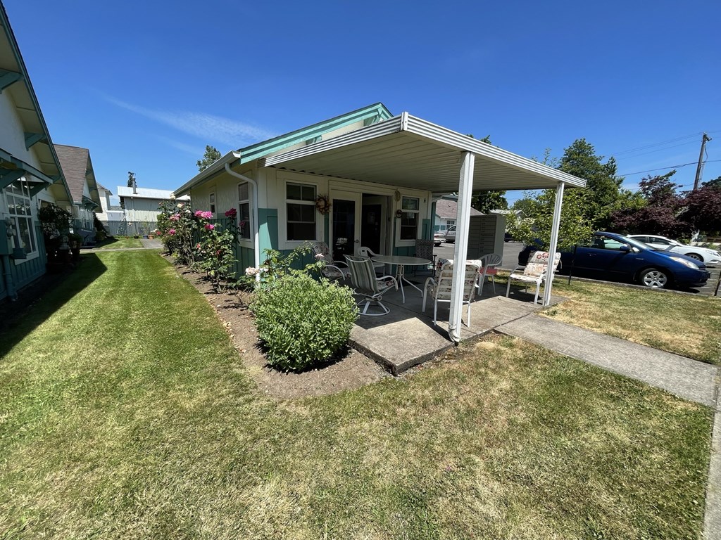 a small house with a porch and a lawn