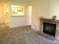 A living room with a fireplace and a painting on the wall.