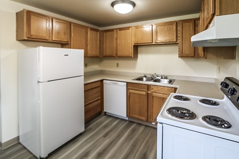 A white refrigerator is in a kitchen with wooden cabinets.