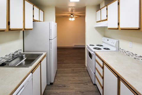 A kitchen with white appliances and wooden cabinets.