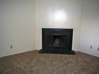 A black fireplace in a room with a brown carpet.