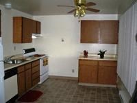 A kitchen with wooden cabinets and a fan.