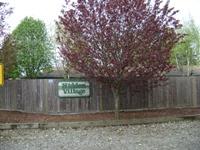 A sign on a fence that says "Village".