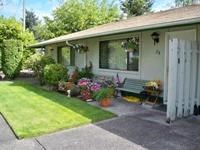 A house with a green lawn and a white fence.