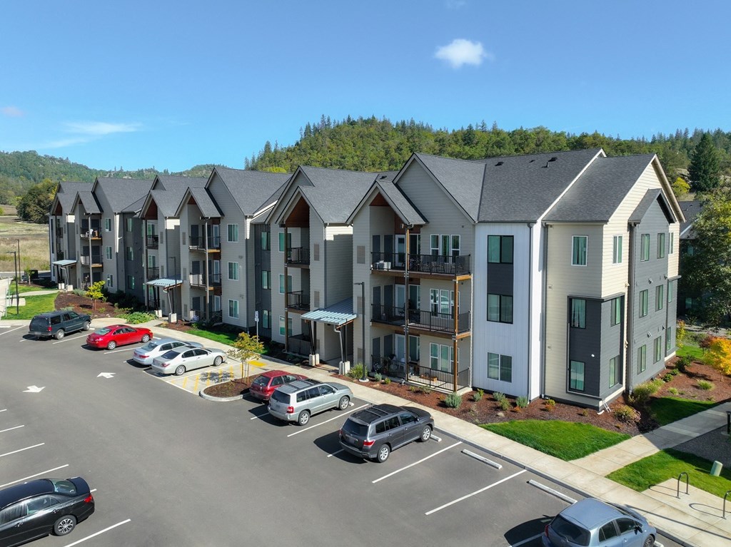 an aerial view of an apartment complex with cars parked in a parking lot