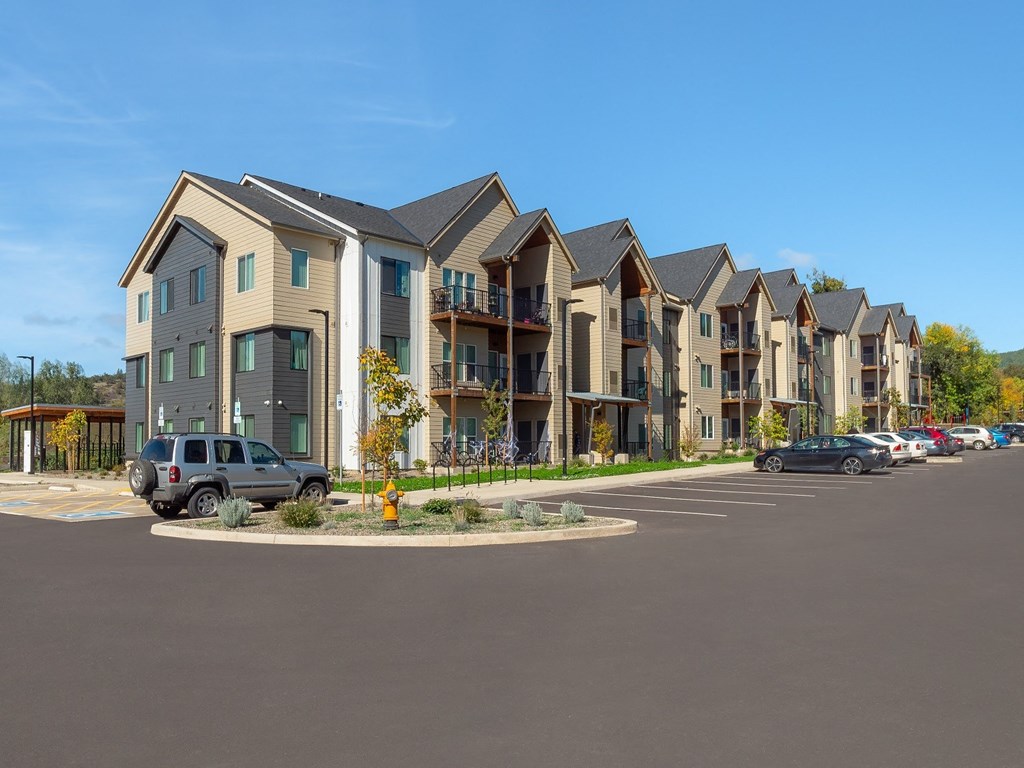 an empty parking lot in front of an apartment building