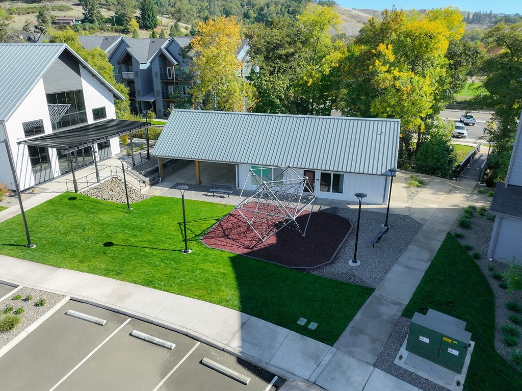 an aerial view of a swing set in front of a house
