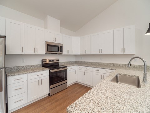 a kitchen with granite counter tops and white cabinets