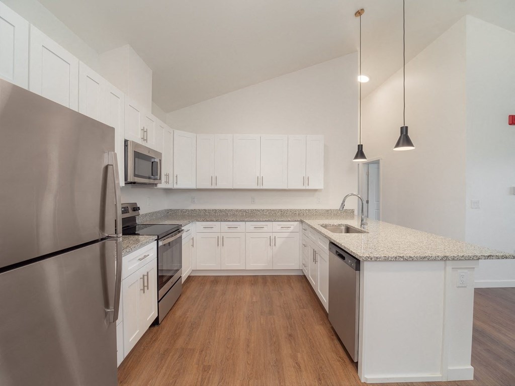 a kitchen with white cabinets and stainless steel appliances