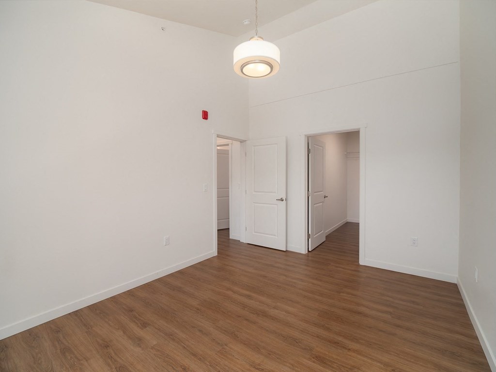 an empty living room with white walls and wood flooring