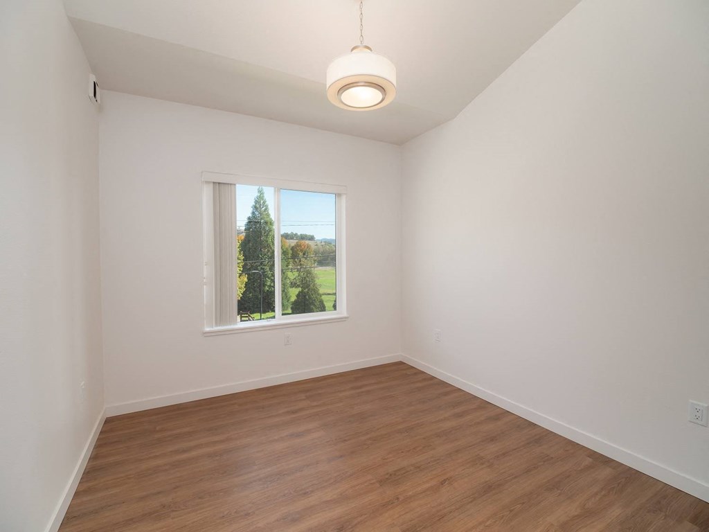 a living room with wood floors and a window