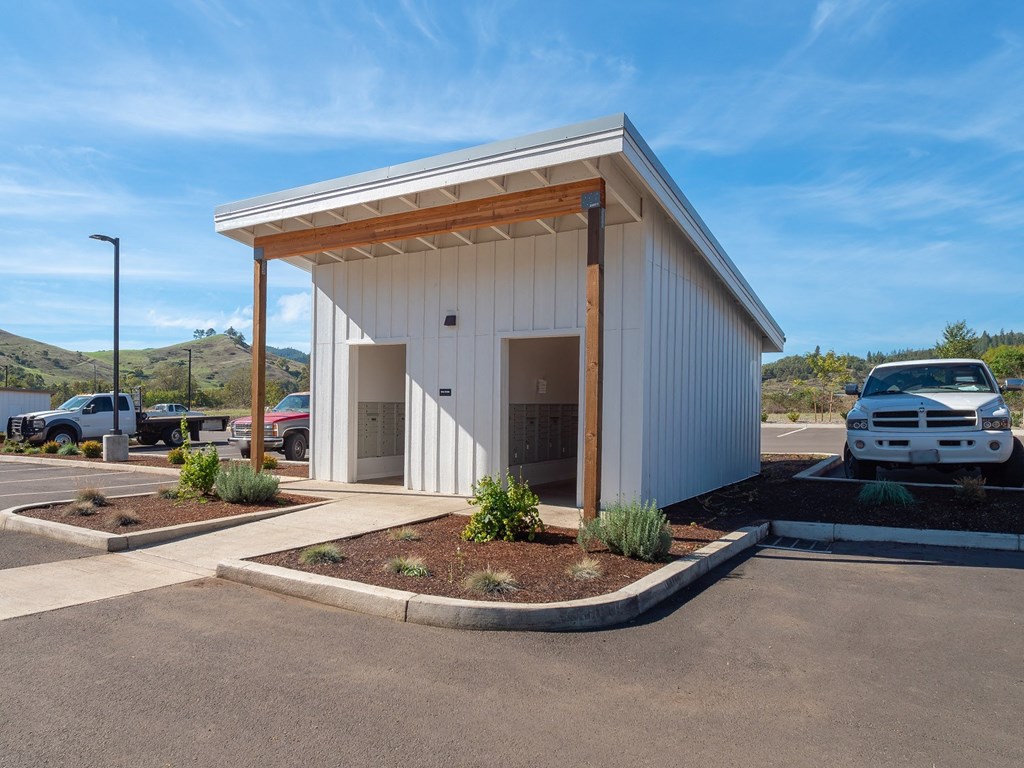 a parking lot with a white building with a car parked in it